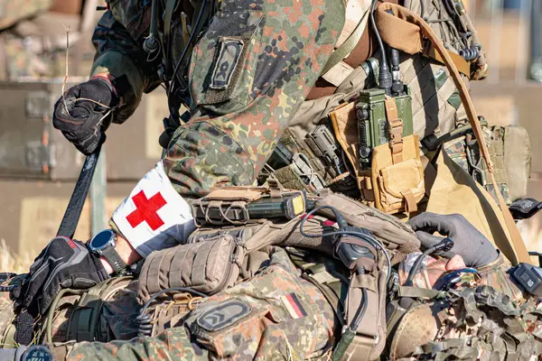 Alman Bundeswehr paraşütçüleri tüfek ve taktik teçhizatla NATO tatbikatına katıldılar. Askerler, savaş hazırlığı, takım çalışması ve acil müdahale eğitimleri sırasında yaralı yoldaşlara yardım ediyor..