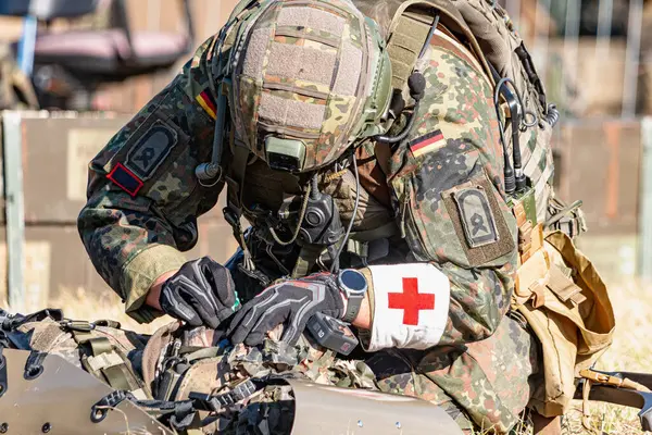 Alman Bundeswehr paraşütçüleri tüfek ve taktik teçhizatla NATO tatbikatına katıldılar. Askerler, savaş hazırlığı, takım çalışması ve acil müdahale eğitimleri sırasında yaralı yoldaşlara yardım ediyor..