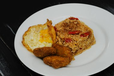 Kızarmış pirinç nugget ve beyaz tabakta kızarmış yumurta.