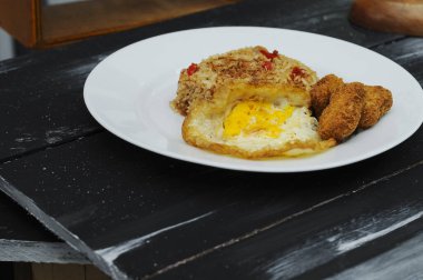Kızarmış pirinç nugget ve beyaz tabakta kızarmış yumurta.