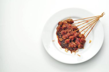 grilled meatballs on a plate of puti, spicy sauce and peanut sauce clipart