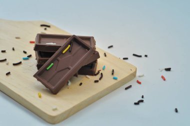 Tahta altlıklı çikolata, beyaz arka plan.