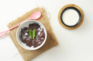 Beyaz arka planda hindistan cevizi sütüyle siyah glutinous Rice Lapası veya Bubur Pulut Hitam