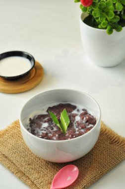 Beyaz arka planda hindistan cevizi sütüyle siyah glutinous Rice Lapası veya Bubur Pulut Hitam