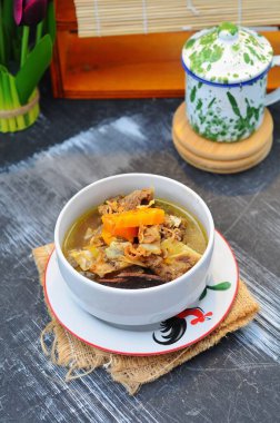 Kaynamış kemik ve et suyu. Beyaz kâsede ev yapımı sığır eti çorbası servis edilir.