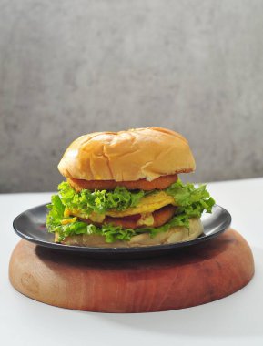 Bir parça kızarmış tavuk, bir burger ve tabakta bir parça peynir ile hamburger. Fast food konsepti.