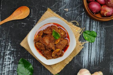 Rendang Jengkol, baharat ve hindistan cevizi sütüyle kaynatılmış köpek meyvesi. Geleneksel Endonezya yemekleri, baharatlı lezzet tadı tipik rendang ve yasal jengkol dokusu.