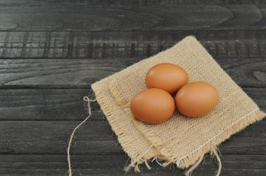 Çuval bezinde tavuk yumurtası ve siyah masa.