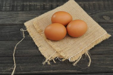 Çuval bezinde tavuk yumurtası ve siyah masa.