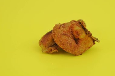 Sarı arka planda kızarmış tavuk bacağı.
