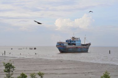 Sabah bulutlu bir gemi sahilde