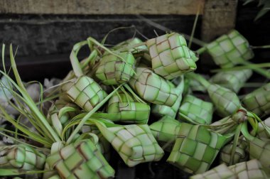 Ketupat (in Indonesian and Malay), or kupat (in Javanese and Sundanese), or tipat (in Balinese) is a Javanese rice cake packed inside a diamond-shaped container of woven palm leaf pouch, clipart