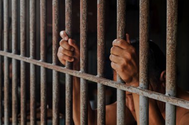 Hapishane elleri adam hapse barlar çelik kafes tutun, Erkek mahkumlar ciddi gergin karanlık hapishane, şiddet, insan ticareti, hapishane ve mahkum kavramı içinde.