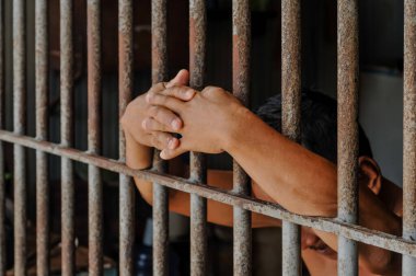 Hapishane elleri adam hapse barlar çelik kafes tutun, Erkek mahkumlar ciddi gergin karanlık hapishane, şiddet, insan ticareti, hapishane ve mahkum kavramı içinde.