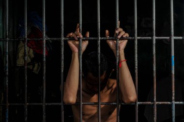 Hapishane elleri adam hapse barlar çelik kafes tutun, Erkek mahkumlar ciddi gergin karanlık hapishane, şiddet, insan ticareti, hapishane ve mahkum kavramı içinde.