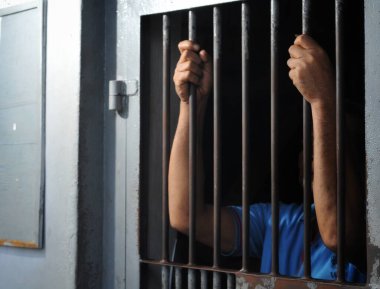 Hapishane barının arkasındaki adamın eli.