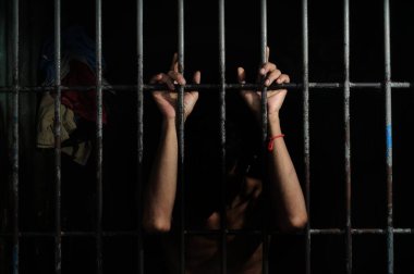 Hapishane barının arkasındaki adamın eli.