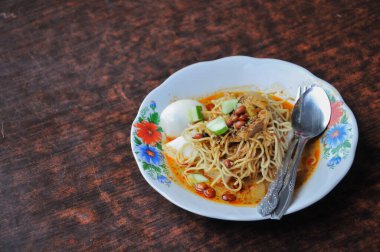 lontong noodles on a white plate on the table clipart