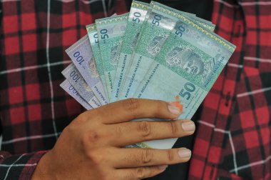 El ele tutuşan Malezya ringgit para birimi