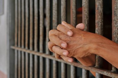 Siyah arka planda bir mahkumun elleri