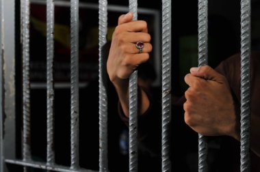 Siyah arka planda bir mahkumun elleri