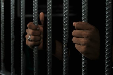 Siyah arka planda bir mahkumun elleri