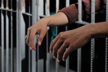 Siyah arka planda bir mahkumun elleri