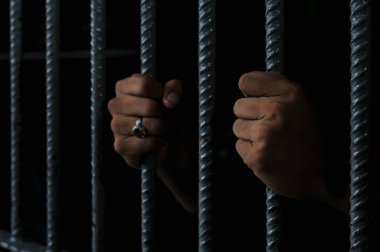 Siyah arka planda bir mahkumun elleri