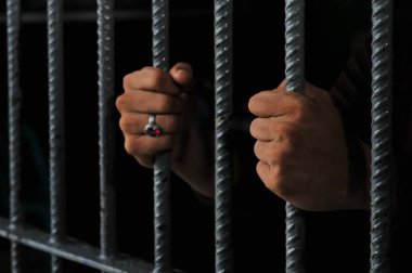 Siyah arka planda bir mahkumun elleri