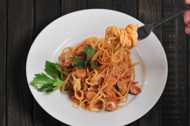 Kahverengi arka planda yeşil fesleğenli spagetti bolonez manzarası. Makale, gıda ürünü ve ticari kullanım için mükemmel