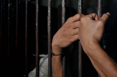Siyah arka planda bir mahkumun elleri