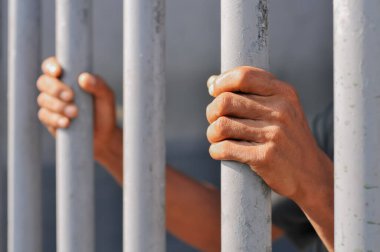 Siyah arka planda bir mahkumun elleri