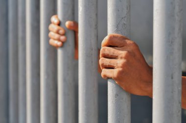 Siyah arka planda bir mahkumun elleri