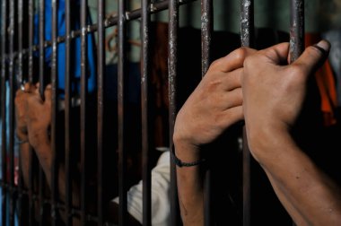 Siyah arka planda bir mahkumun elleri