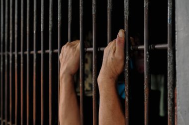 Siyah arka planda bir mahkumun elleri