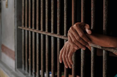 Siyah arka planda bir mahkumun elleri