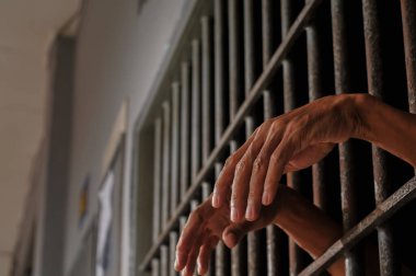 Siyah arka planda bir mahkumun elleri