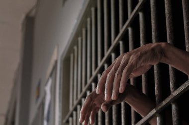 Siyah arka planda bir mahkumun elleri
