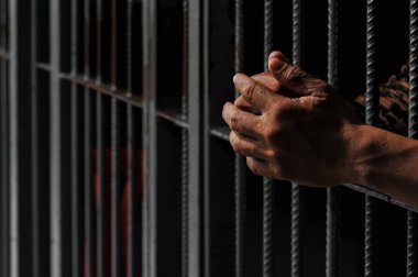 Siyah arka planda bir mahkumun elleri
