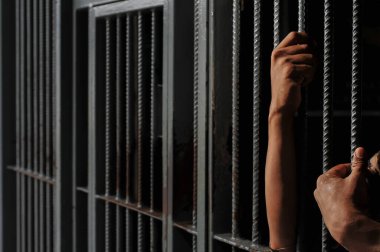 Siyah arka planda bir mahkumun elleri