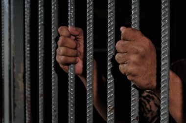 Siyah arka planda bir mahkumun elleri