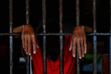 Siyah arka planda bir mahkumun elleri