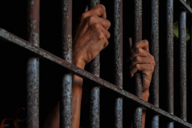 Siyah arka planda bir mahkumun elleri