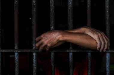 Siyah arka planda bir mahkumun elleri