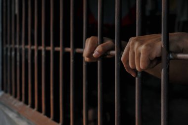 Siyah arka planda bir mahkumun elleri
