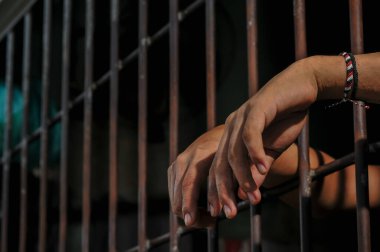 Siyah arka planda bir mahkumun elleri