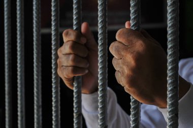 Siyah arka planda bir mahkumun elleri