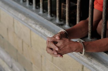 Siyah arka planda bir mahkumun elleri