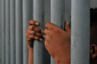 Siyah arka planda bir mahkumun elleri