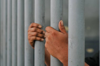 Siyah arka planda bir mahkumun elleri